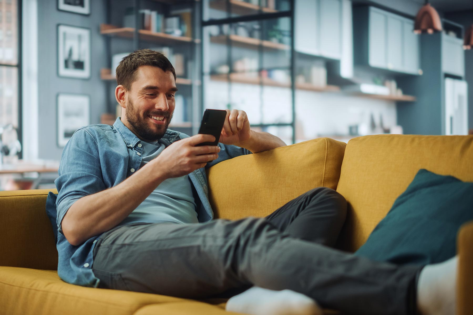 Man sitting on sofa at home on video session within the HOME platform.